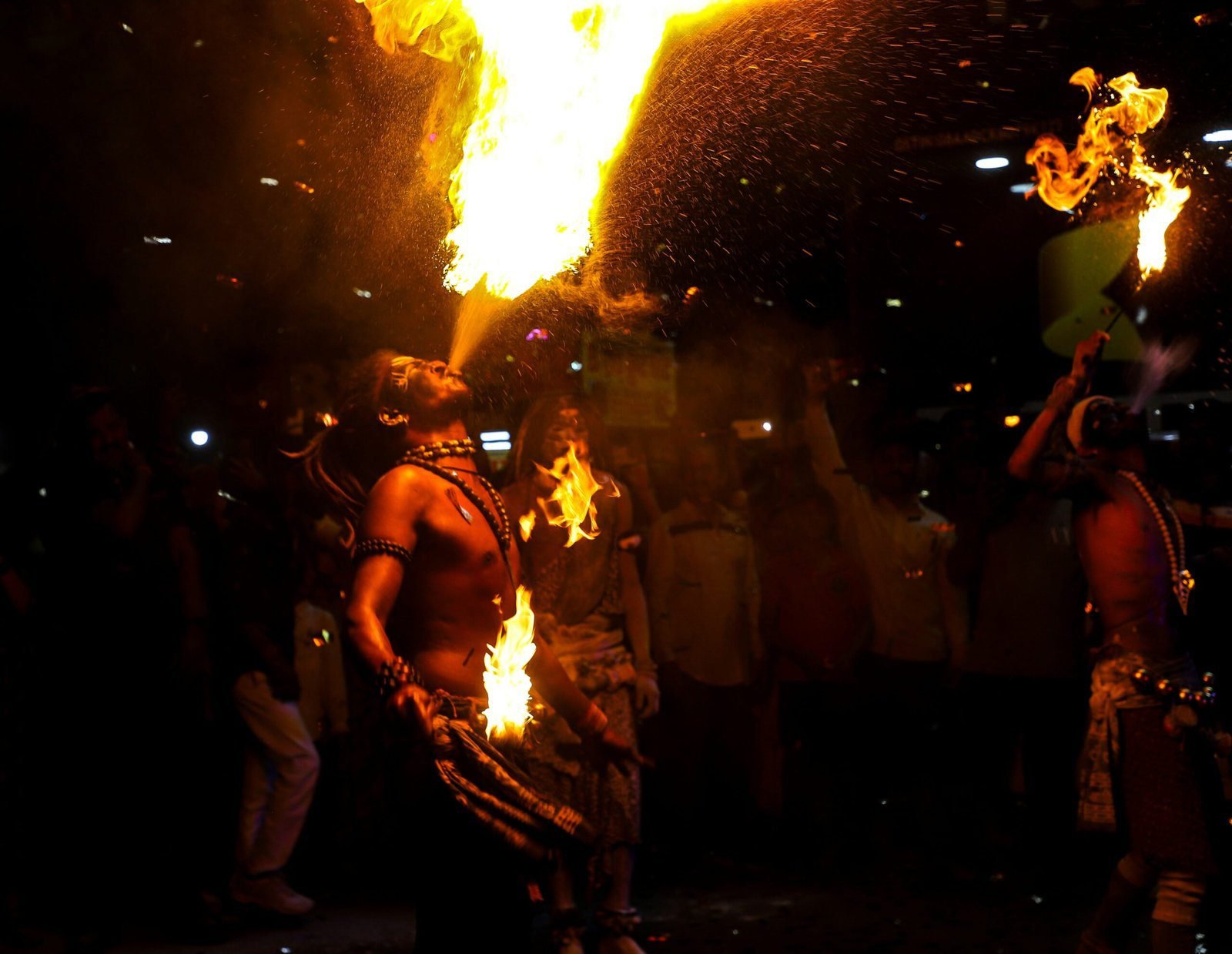 a group of people standing around a fire pit